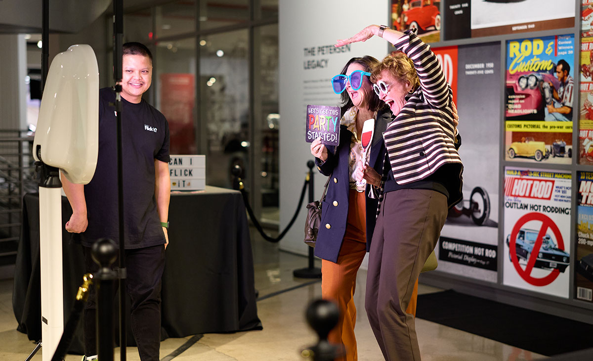 Two guests of LMU Loyola Law School's Grand Reunion pose with props in a photobooth.